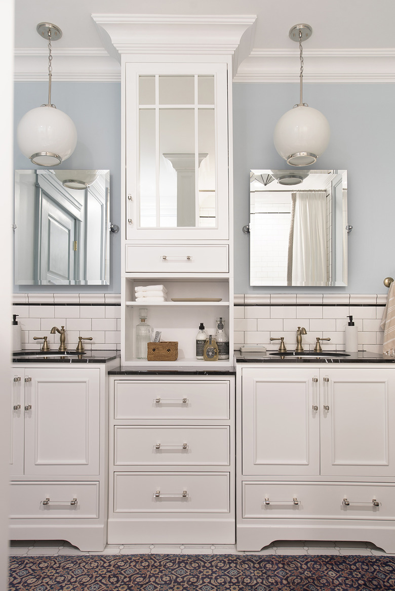 Double bathroom vanity with white cabinets and globe pendant lights