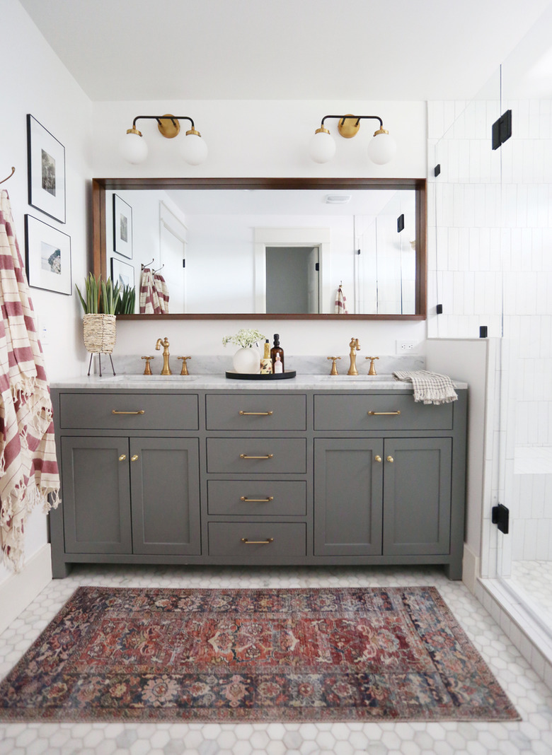 Double bathroom vanity with gray cabinets and wall sconces