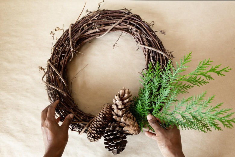 attaching cedar branches to a grapevine wreath
