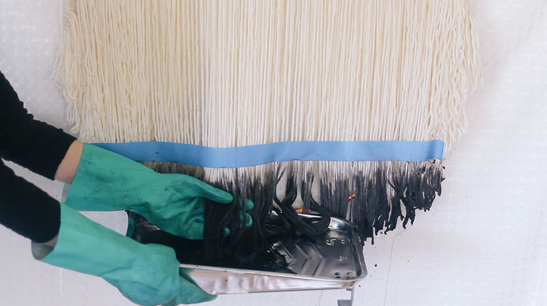 Dip dyeing the bottom of yarn strands into black dye