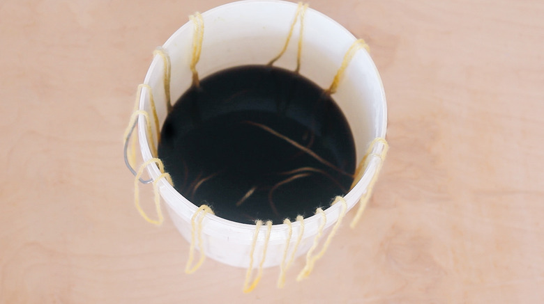 Yarn strands soaking in tan dye
