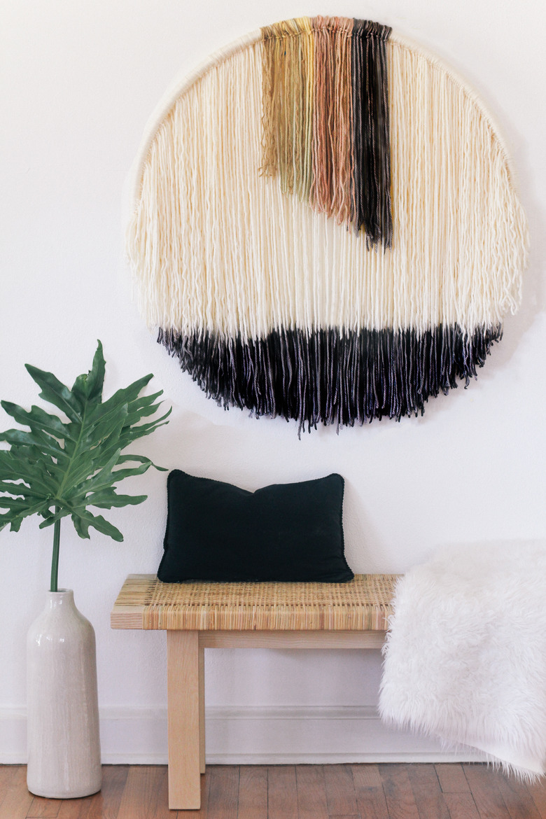 Round wall art hanging above bench