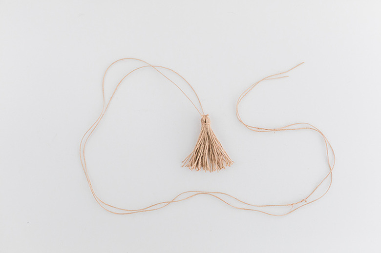 Close the tassel around the long piece of twine