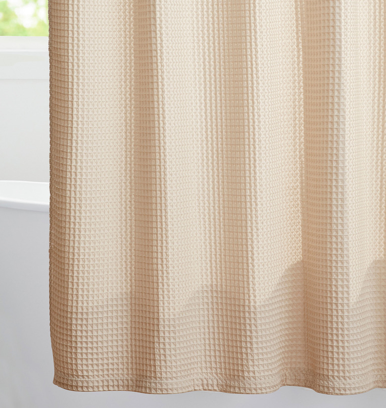 Beige waffle eco-friendly shower curtain in white bathroom with bathtub