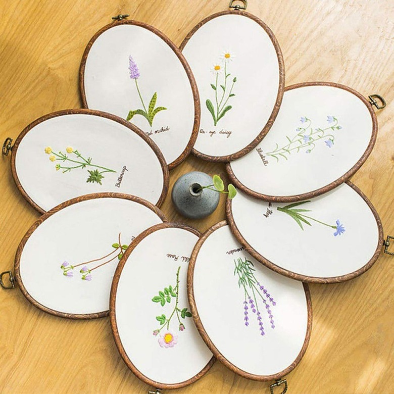 a group of oval embroidery hoop with flower patterns arrange in a circle