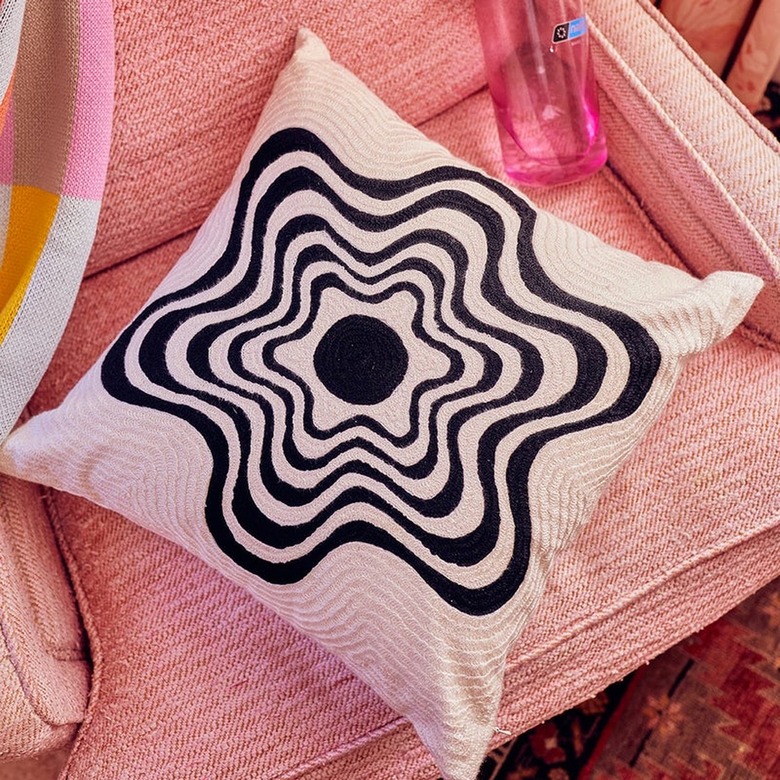 A white pillow with a black ripply design on it