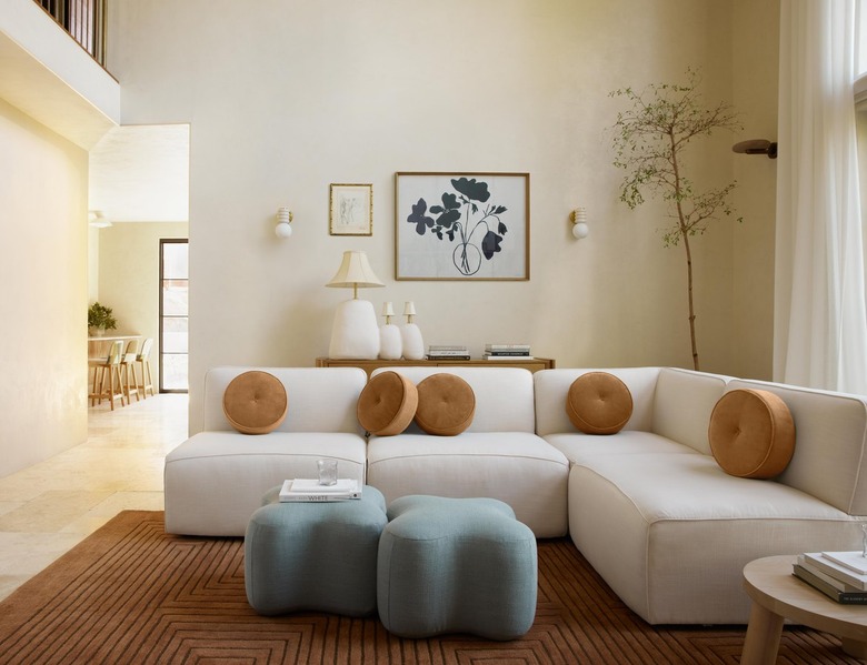 Living room with white couch circular throw pillows and blue ottomans