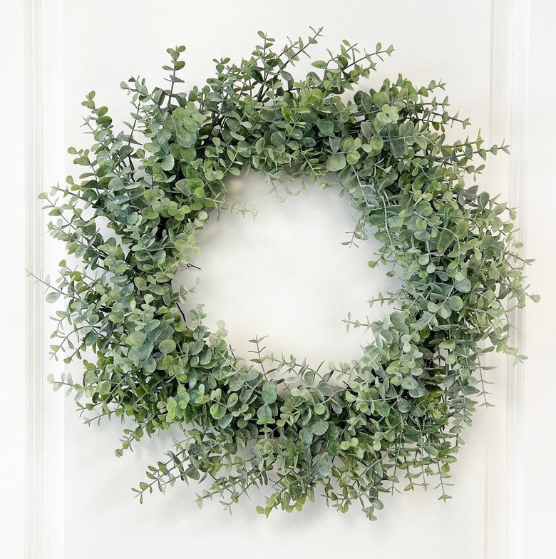 A eucalyptus wreath on a white door