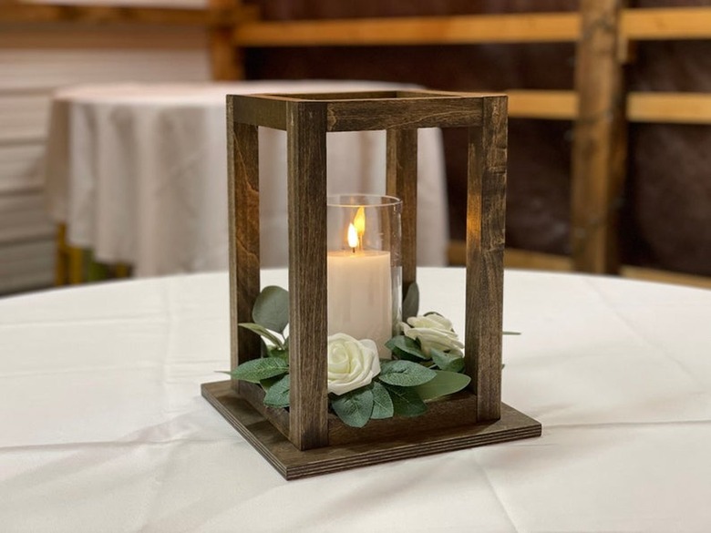 wood lantern centerpiece with greenery and candle