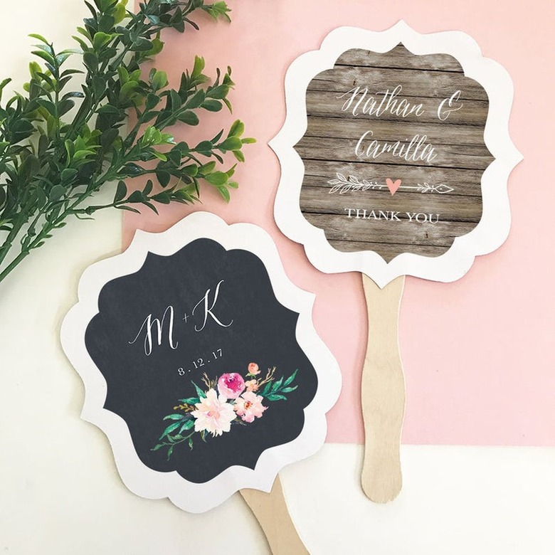 two fans on white and pink background with foliage nearby