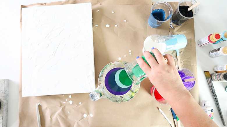 Pouring paint into measuring cup.