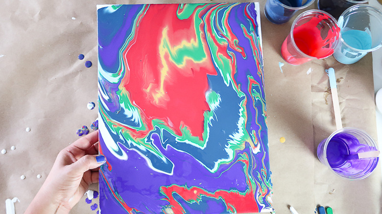 Spreading paint by tilting canvas.