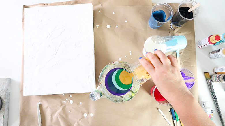 Pouring paint into measuring cup.