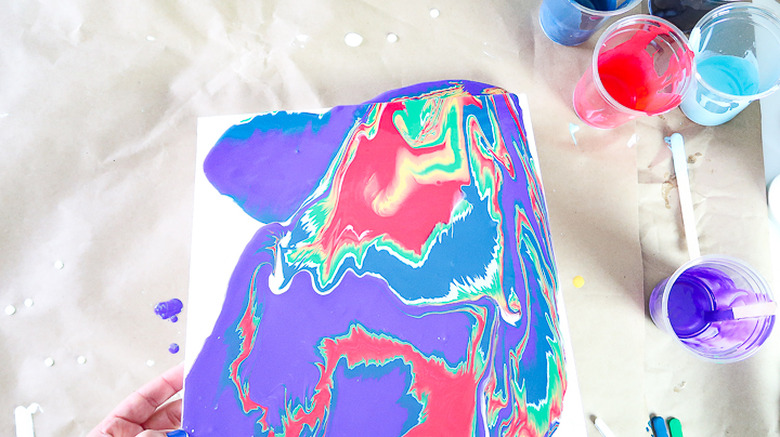 Spreading paint by tilting canvas.