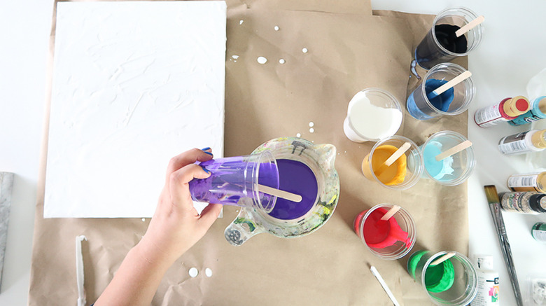 Pouring paint into measuring cup.
