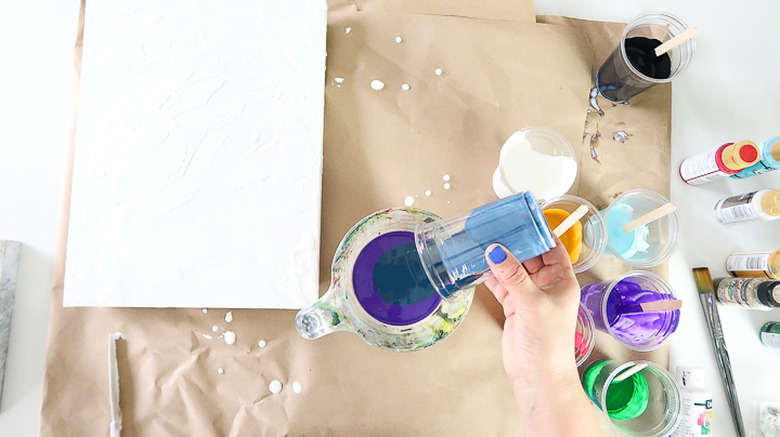Pouring paint into measuring cup.