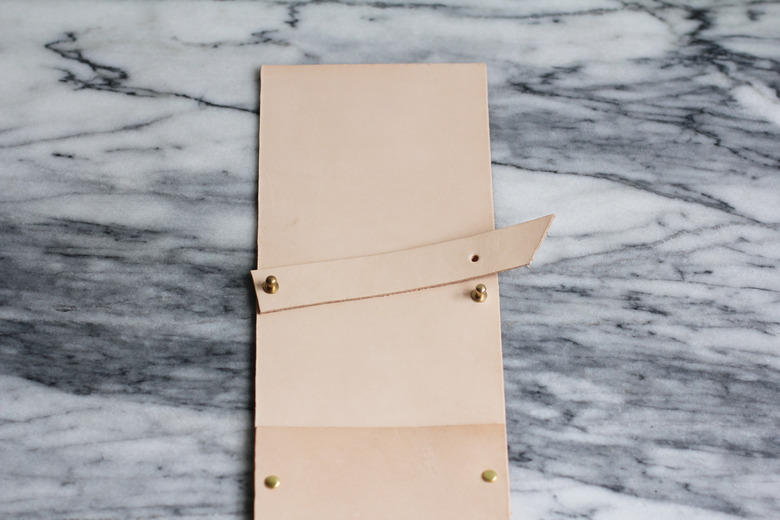 Brass stud screwbacks attached through holes on leather strip