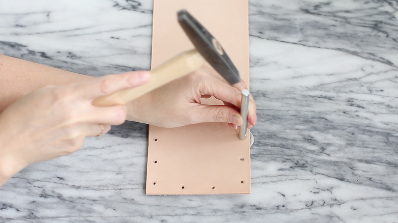 Hammering cap of rivet onto base of rivet