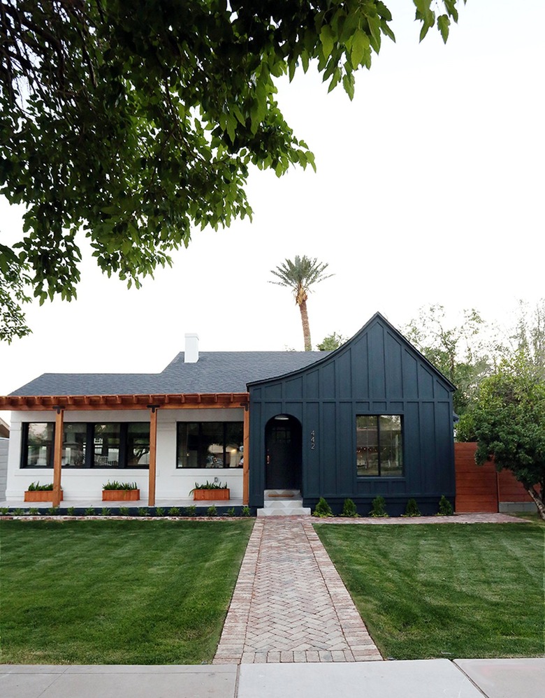 Emerald green and white home with a black roof