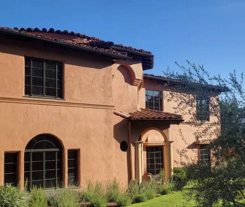 Terra cotta home exterior with black windows.