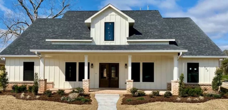 Off-white home exterior with black windows.