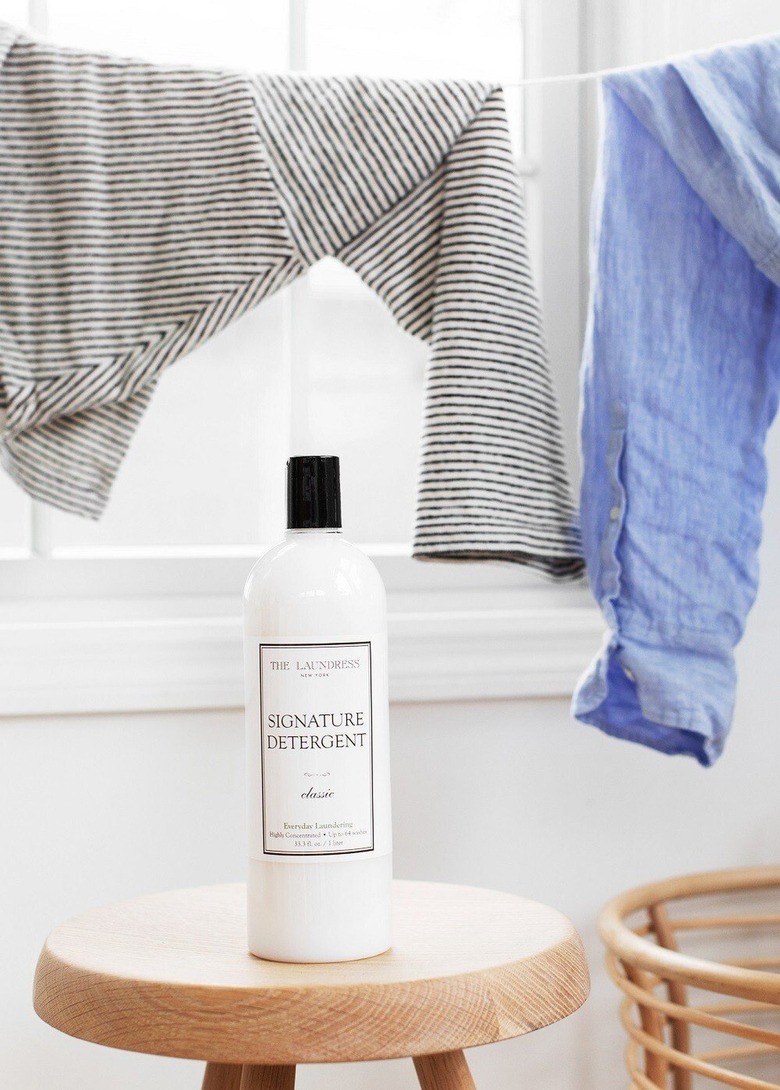 bottle of detergent near hanging towels