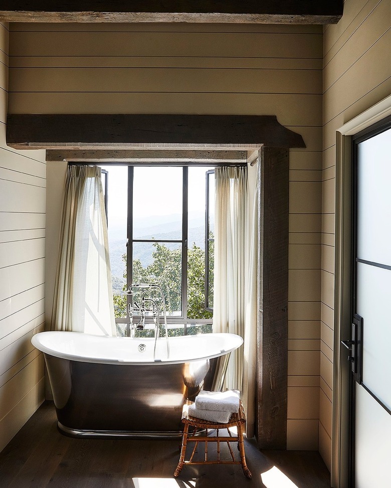 farmhouse bathroom idea with metal freestanding tub and wood beams overhead