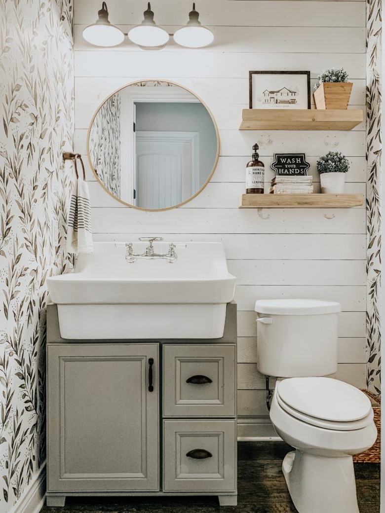 Farmhouse bathroom idea with white shiplap and sage green leaf print wallpapered walls