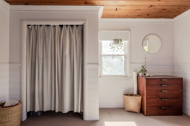 A sunlit bedroom with a curtain divider