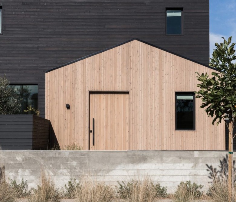 Modern farmhouse with natural and black painted wood exterior.