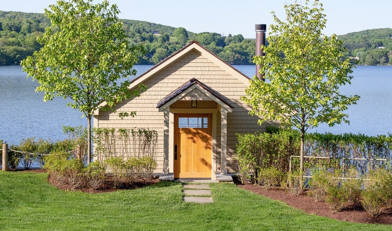Farmhouse on lake with wood shingle siding.