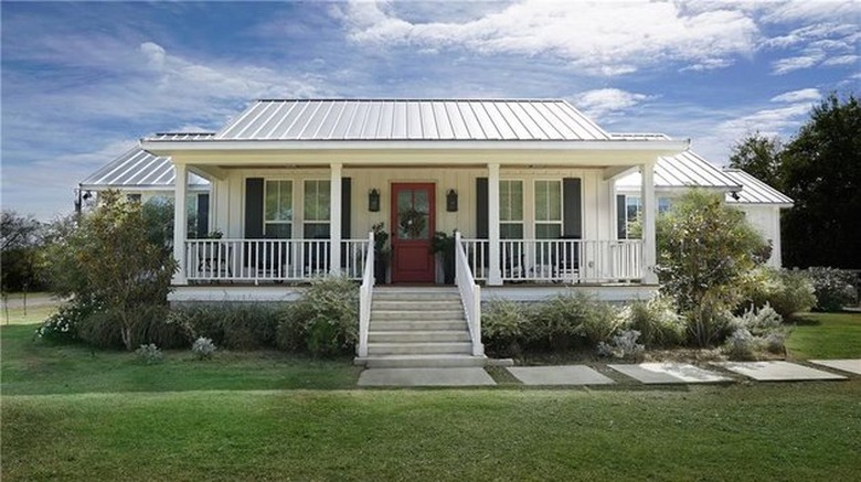 farmhouse style house with white railings and white roof