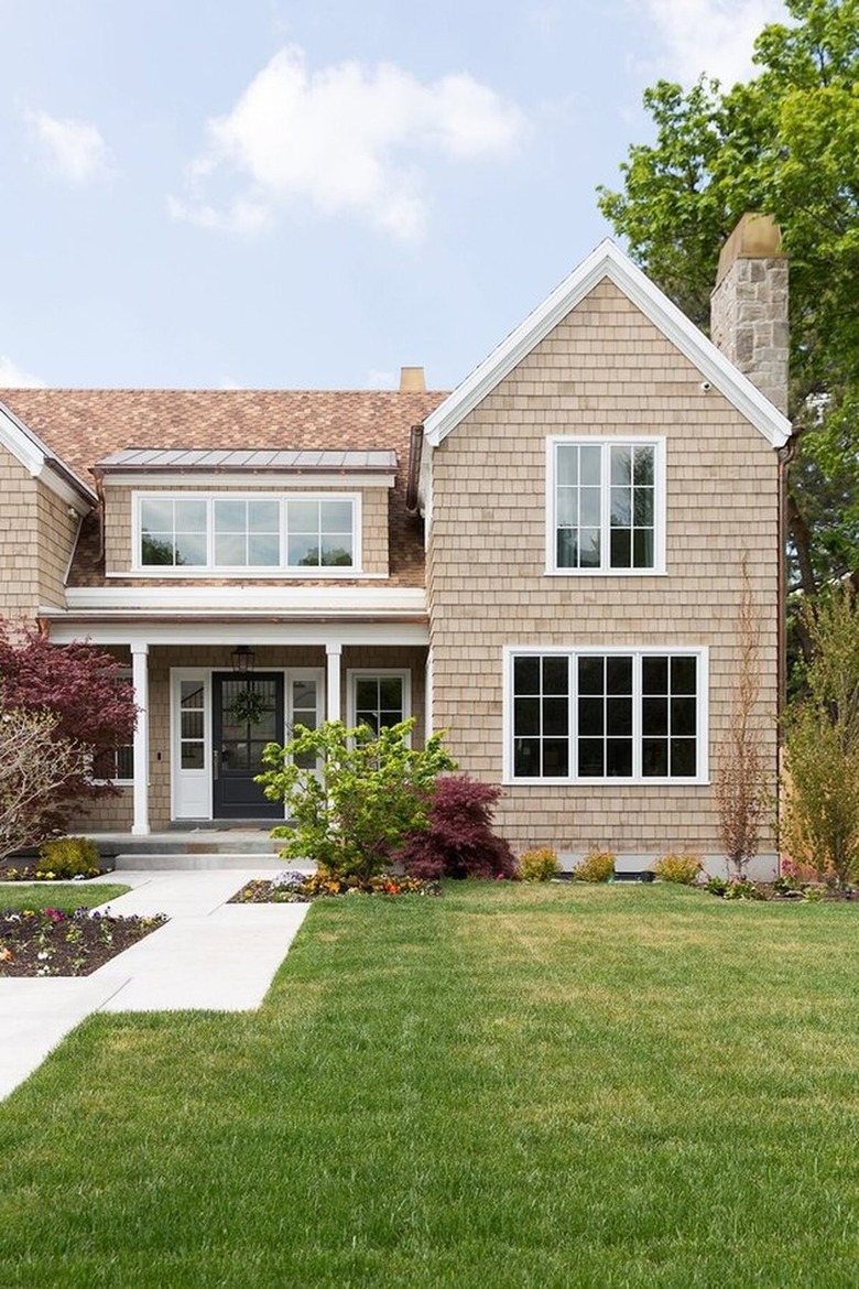 Farmhouse with natural wood stain shingles and white trim.