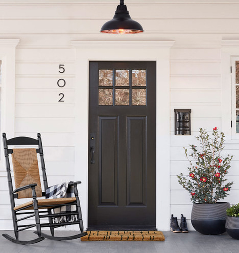 front porch with shiplap style wall and black door