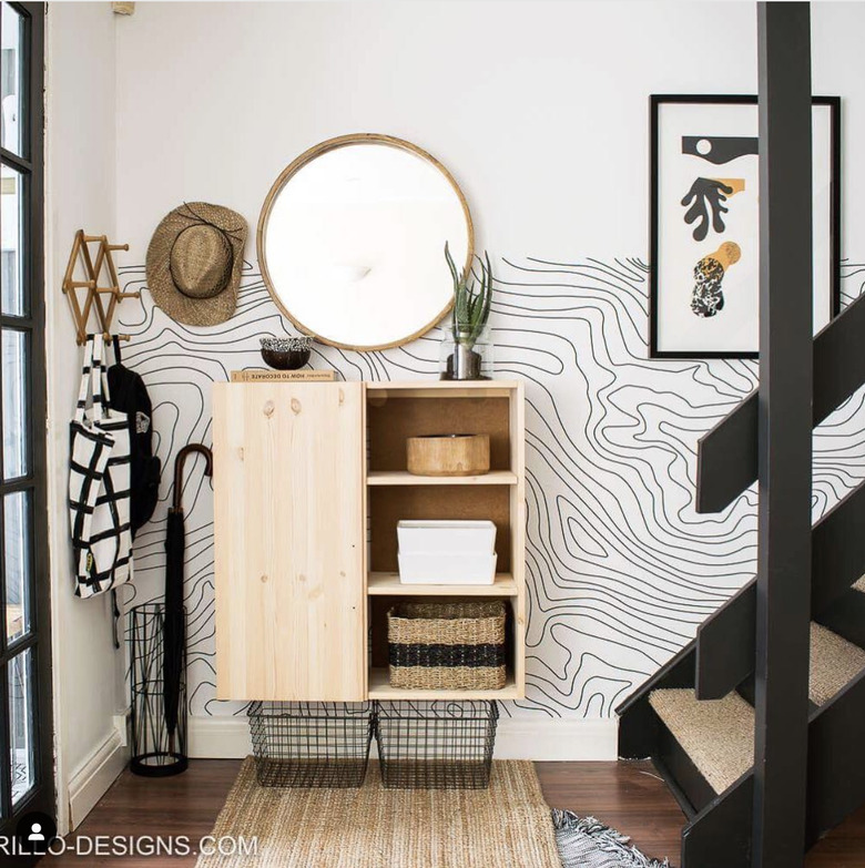 Entryway with mirror and wavy wallpaper.