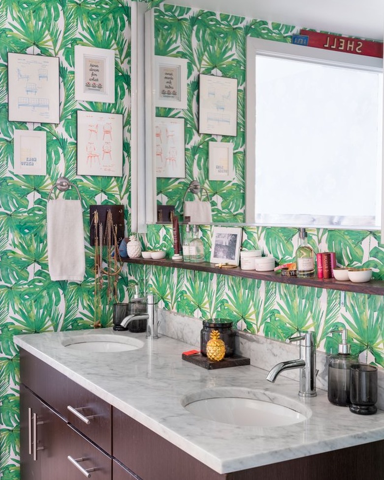 Green palm print wallpaper in bathroom with two sinks.