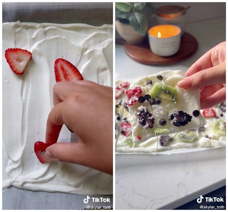 On the left is a hand placing fruit onto a yogurt-covered baking sheet. On the right is a hand holding up yogurt bark with strawberry