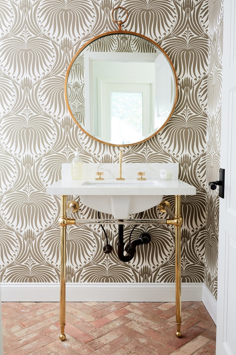 gray bathroom with patterned wallpaper and red brick flooring