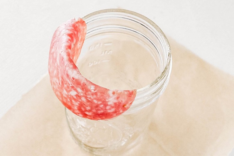 Fold salami over edge of jar