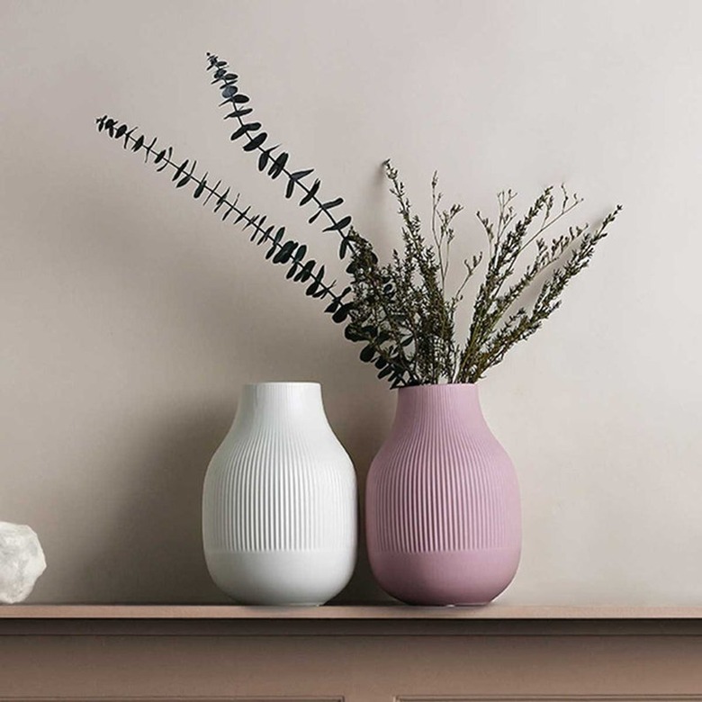 white fluted vase next to pink fluted vase with greenery