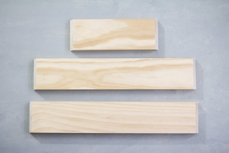 Three plywood panels against grey background