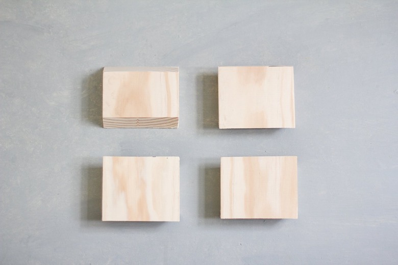 Four stacks of plywood sheets against grey background