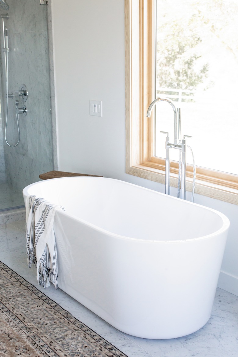 white freestanding tub with striped towel draped over