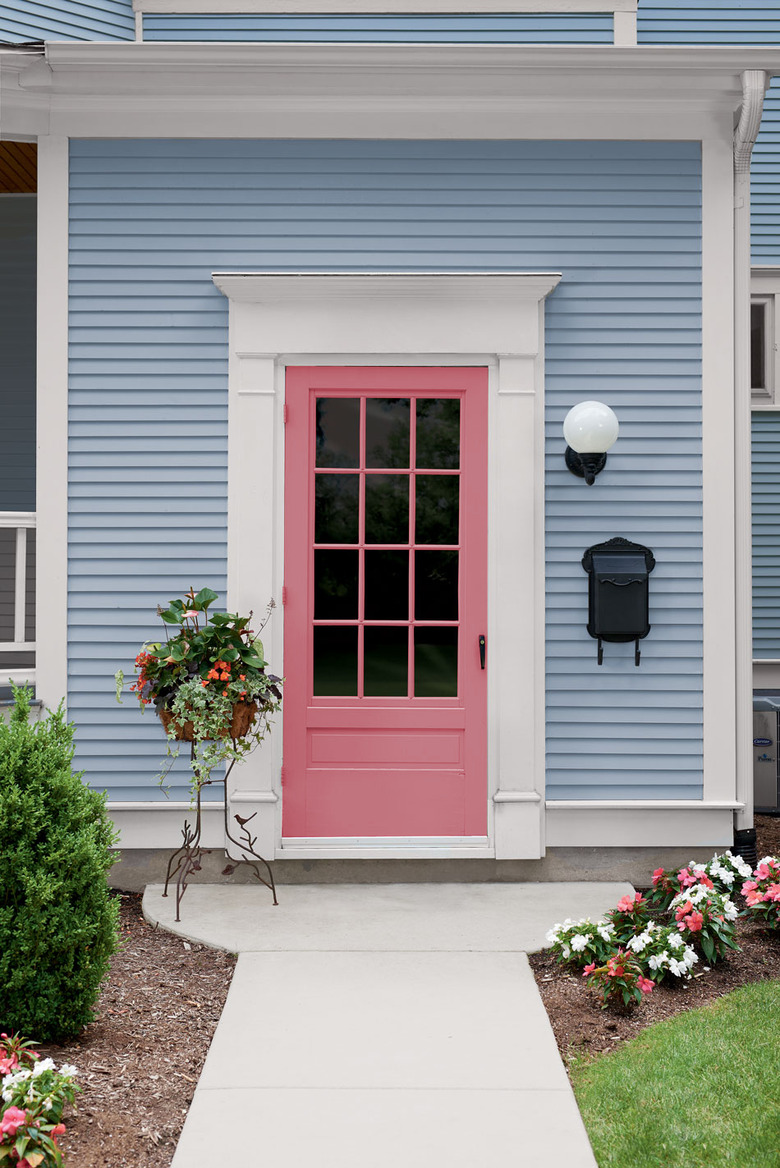 pink front door on light blue house