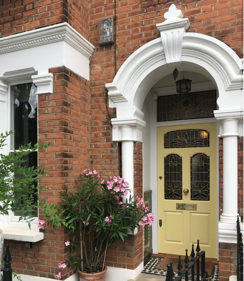 red brick home with butter yellow front door