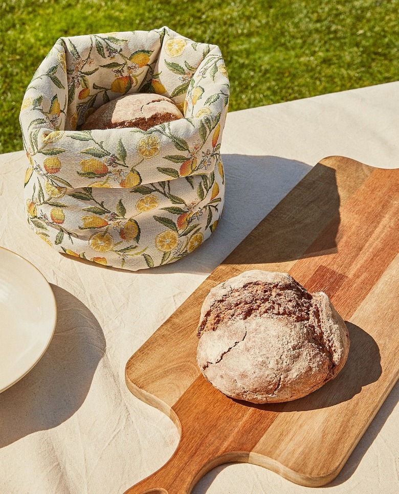 lemon patterned break basket near cutting board with bread