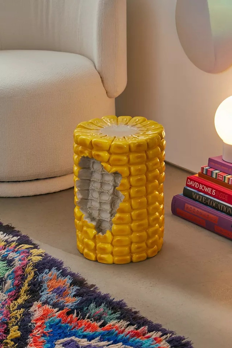 corn shaped stool near couch and lamp with books