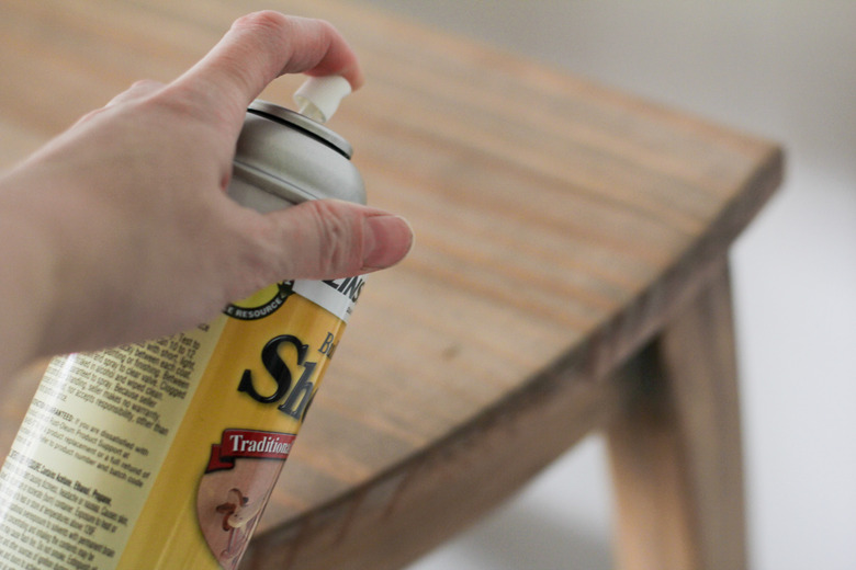 Spraying coat of shellac on table