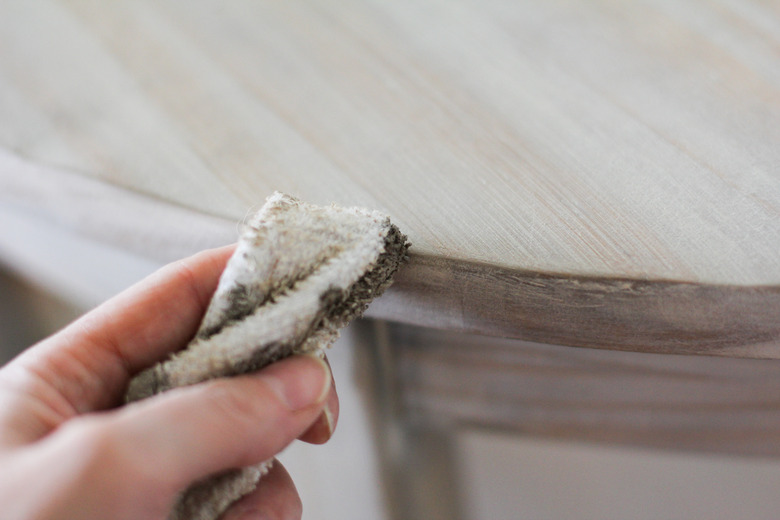 Buffing custom mixed wax color onto table