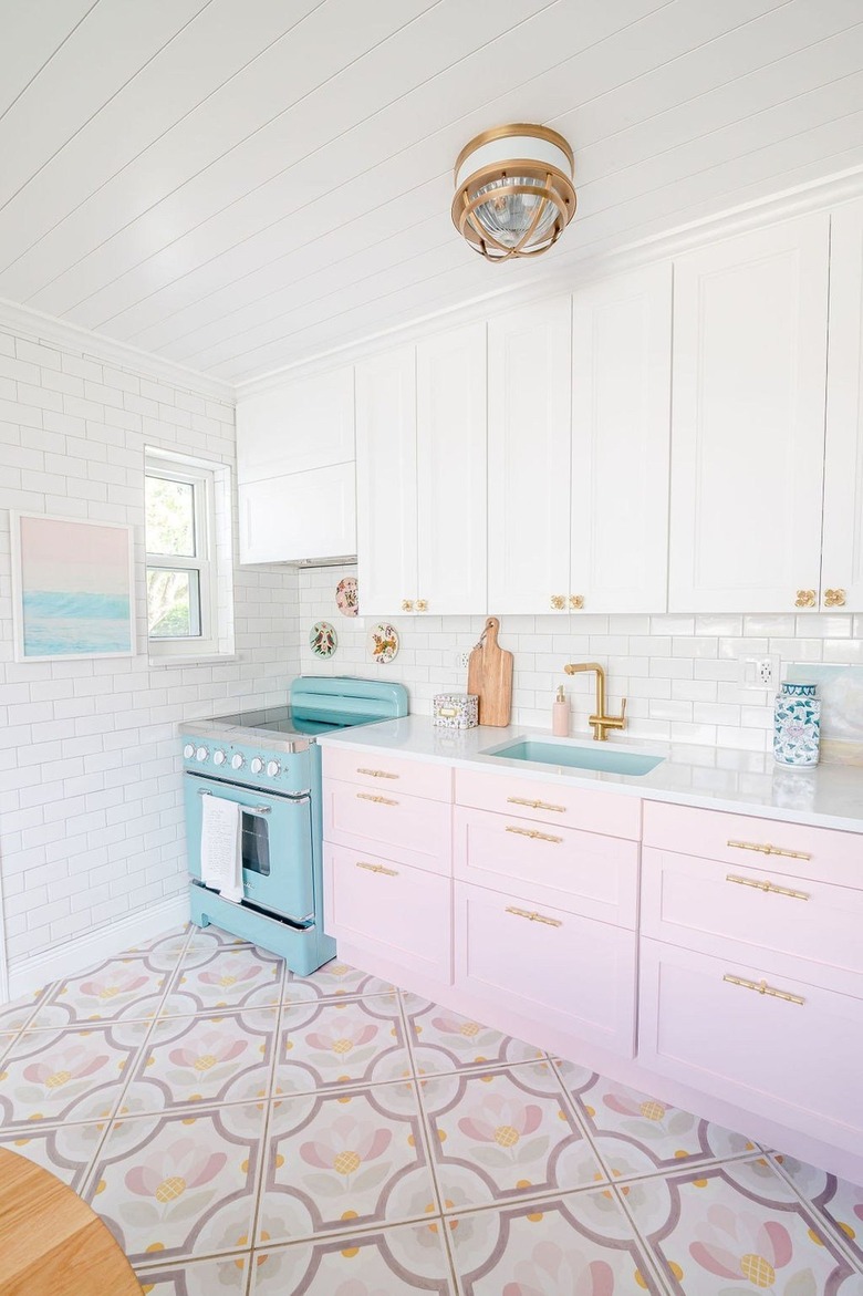 pink and white kitchen with brass hardware